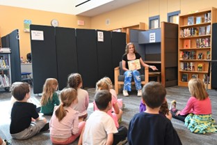 High school student reading to elementary students