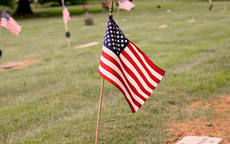 cemetery head stone with American Flag
